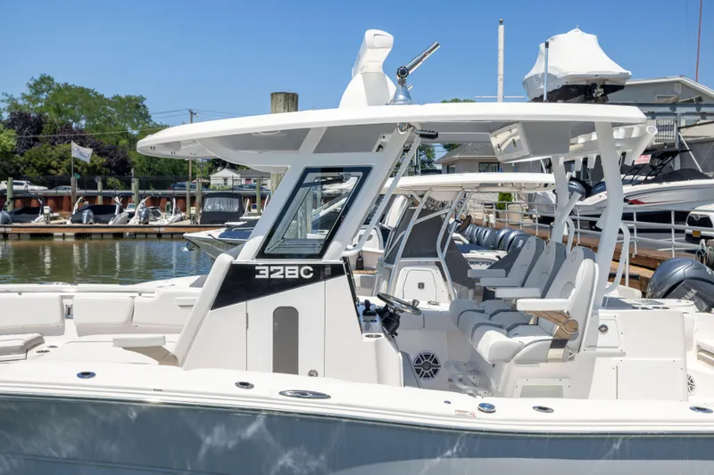 Slide: The Image of A modern, white 2027 Sea Fox 328 Commander docked at a marina, surrounded by other boats. - 4