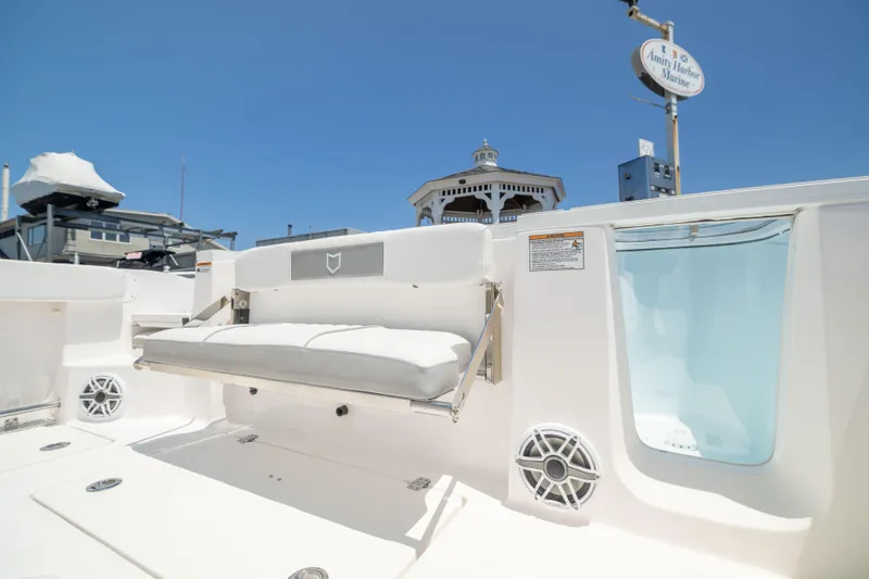 Slide: The Image of A modern boat with a white seating area and speakers, under clear skies at the harbor. - 14