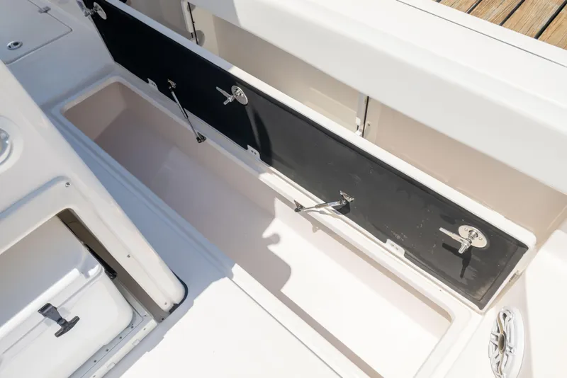 Slide: The Image of An open storage compartment on a boat with multiple latches. - 38