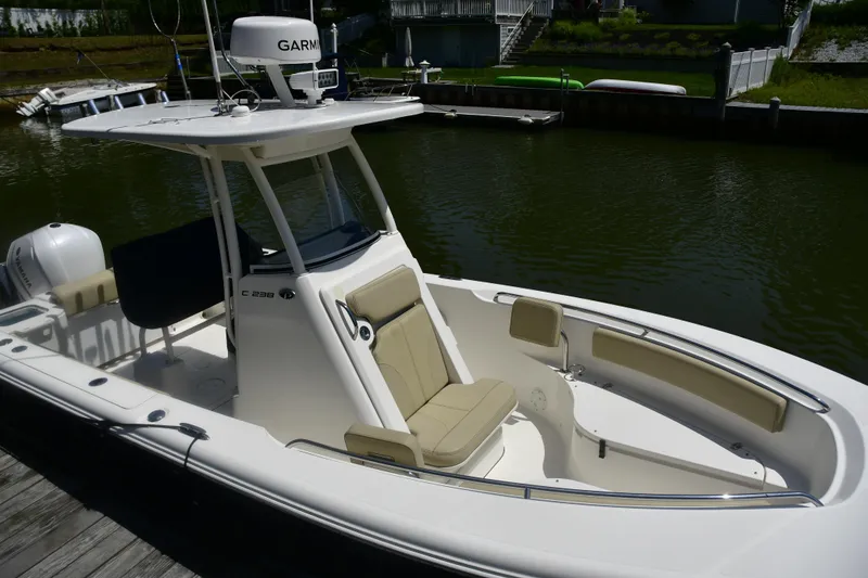 Slide: The Image of 2020 Pursuit C 238 Center Console boat docked by a calm waterfront. - 8