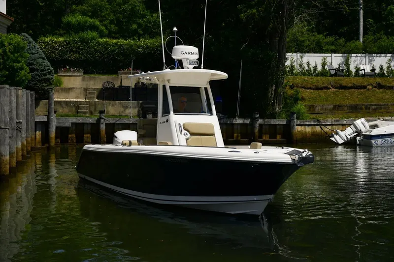 Slide: The Image of 2020 Pursuit C 238 Center Console boat docked in a serene waterfront setting. - 5