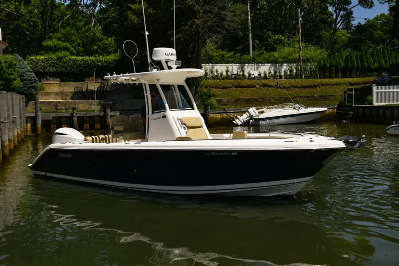 Slide: The Image of 2020 Pursuit C 238 Center Console boat docked in a serene marina setting. - 4