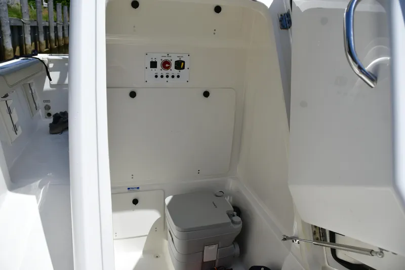 Slide: The Image of 2020 Pursuit C 238 Center Console interior with control panel and portable toilet. - 16