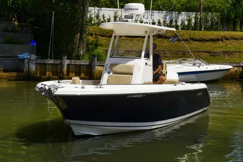 Slide: The Image of 2020 Pursuit C 238 Center Console boat docked in calm waters. - 2