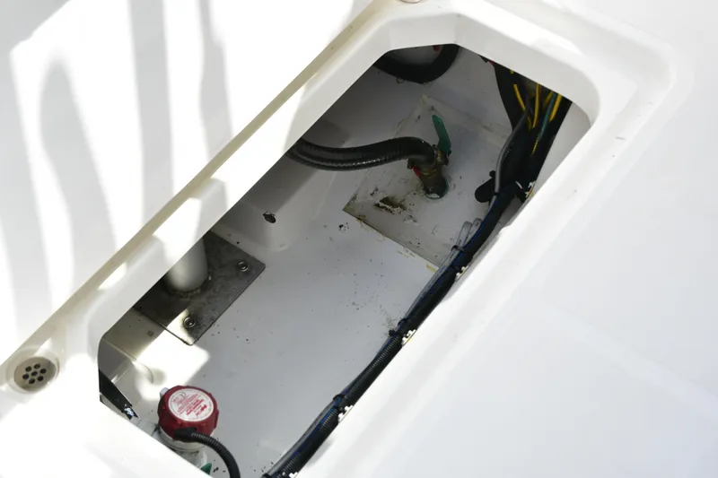 Slide: The Image of 2020 Pursuit C 238 Center Console boat compartment with visible wiring and plumbing. - 18