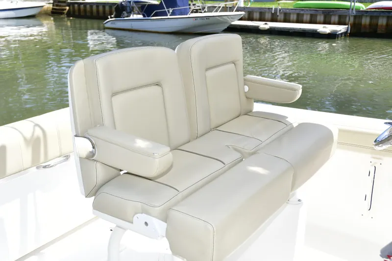Slide: The Image of 2020 Pursuit C 238 Center Console boat with beige seating at a marina. - 9