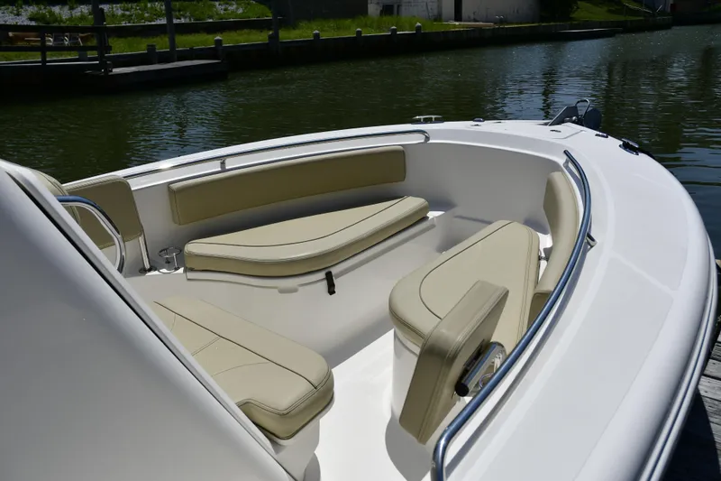 Slide: The Image of 2020 Pursuit C 238 Center Console boat with beige seating, docked on calm water. - 15