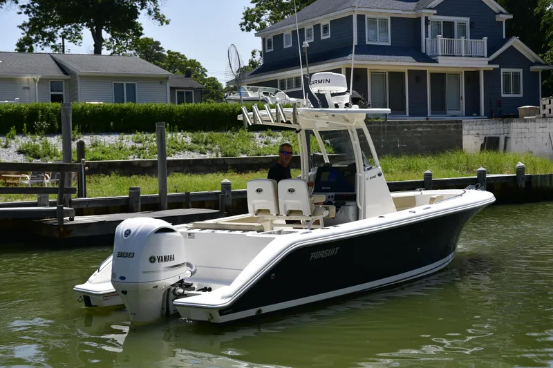 Slide: The Image of 2020 Pursuit C 238 Center Console boat docked near waterfront homes. - 6