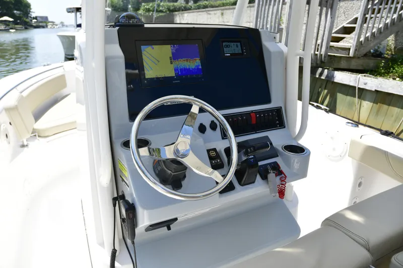 Slide: The Image of 2020 Pursuit C 238 Center Console boat dashboard with steering wheel and navigation display. - 10