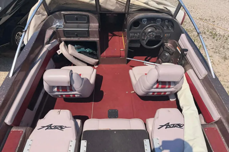 Slide: The Image of Interior of a 1996 Astro 20fsx boat with red carpet and cushioned seats. - 1