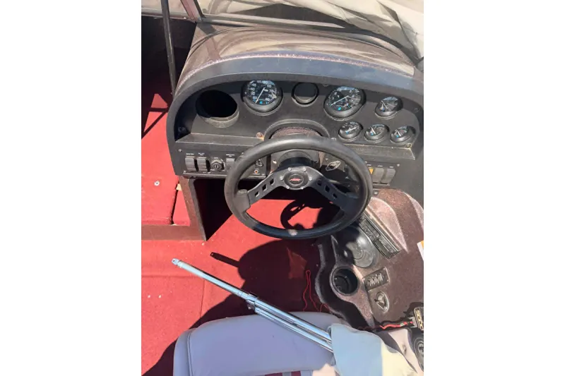 Slide: The Image of 1996 Astro 20fsx boat dashboard with steering wheel and gauges, red carpet interior. - 5