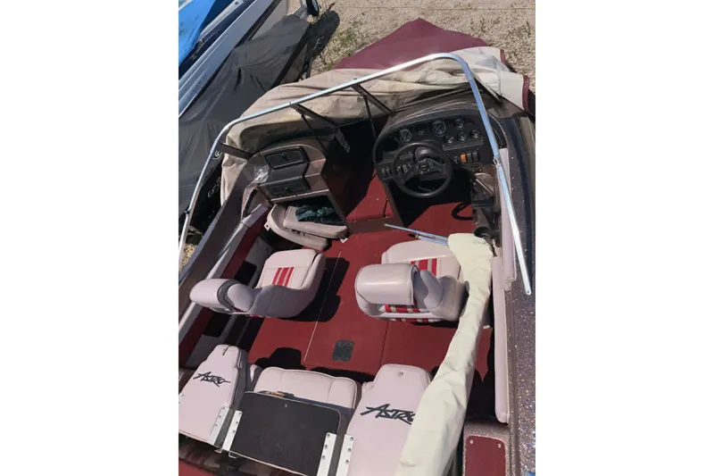 Slide: The Image of 1996 Astro 20fsx boat interior with red and white seating, steering wheel, and dashboard controls. - 3