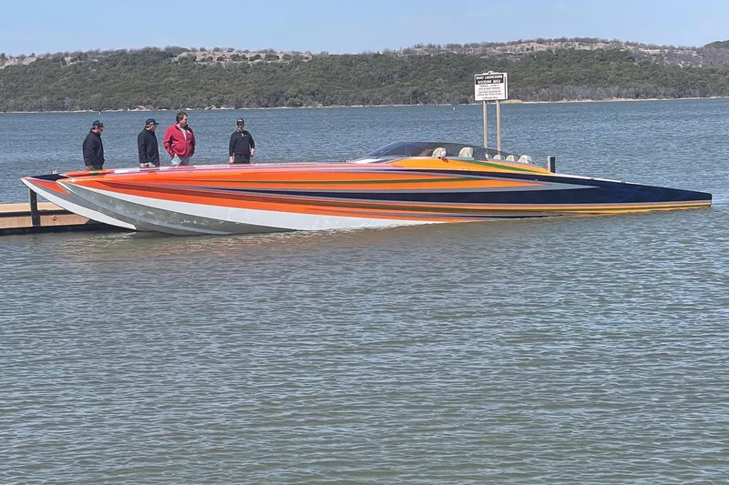 Slide: The Image of A vibrant 2013 Skater 46 speedboat docked on a calm lake with people nearby. - 16