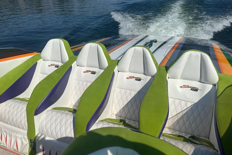 Slide: The Image of Interior of a 2013 Skater 46 boat with green and white seats on water. - 10