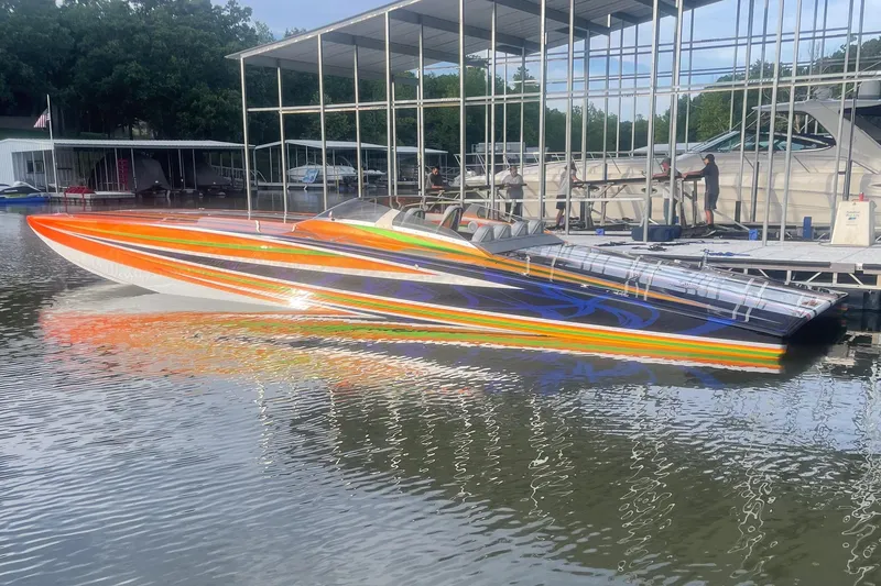 Slide: The Image of Colorful 2013 Skater 46 speedboat docked at marina with vibrant stripes. - 2