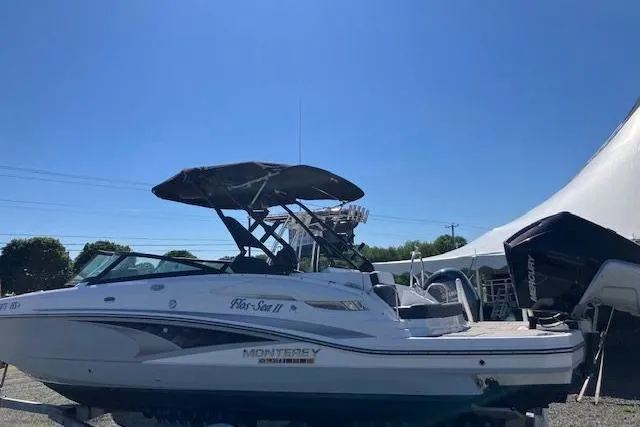 Slide: The Image of 2024 Monterey M-65 boat with canopy, parked outdoors under clear blue sky. - 3