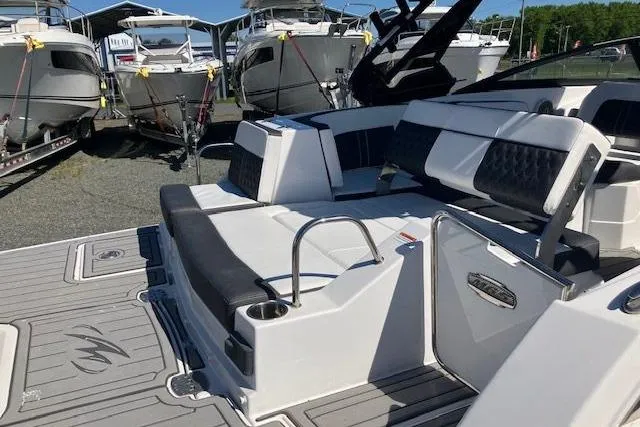 Slide: The Image of 2024 Monterey M-65 boat interior with sleek seating and modern design, docked near other boats. - 5
