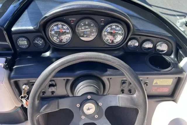 Slide: The Image of Dashboard of a 1996 MasterCraft ProStar 190 boat with steering wheel and gauges. - 13