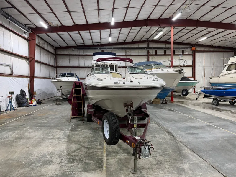 Slide: The Image of A 2006 Crownline 220 EX is on a trailer in a warehouse. - 4