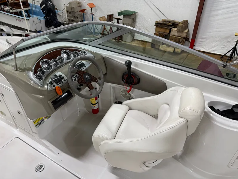Slide: The Image of The image shows the cockpit of a 2006 Crownline 220 EX boat with a white seat and sleek dashboard. - 14