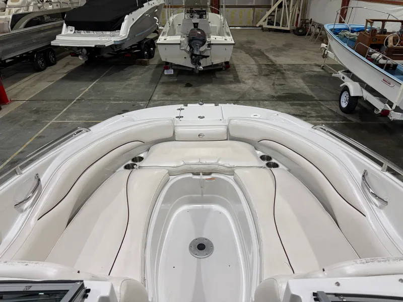 Slide: The Image of The image shows the spacious, white bow area of a Crownline 220 EX boat in a warehouse. - 8