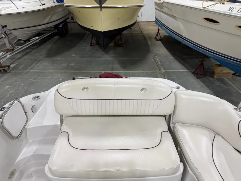 Slide: The Image of A 2006 Crownline 220 EX with white upholstery in the interior, stored in a warehouse. - 13