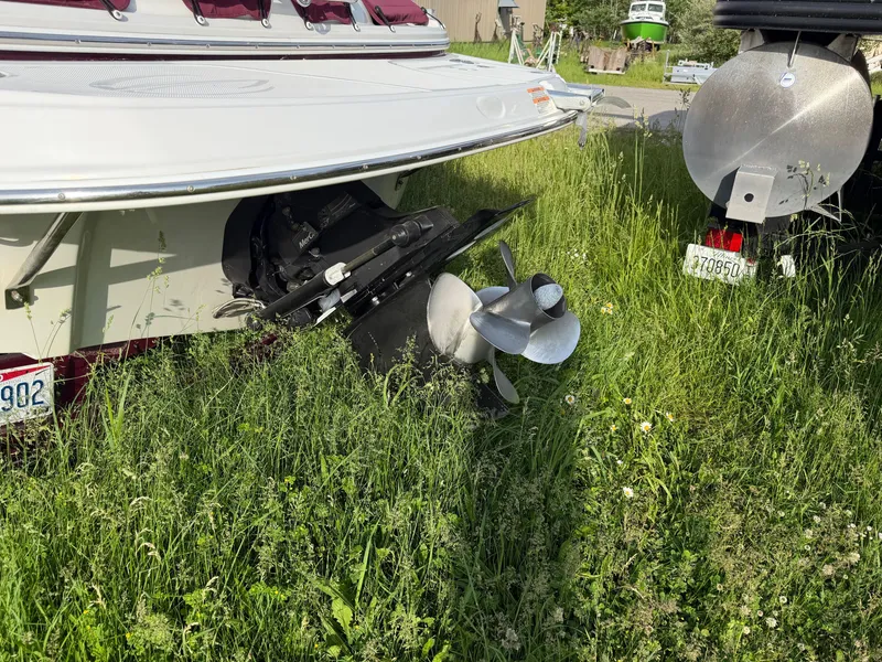 Slide: The Image of A 2006 Crownline 220 EX sits in the grass. The propeller is visible. - 2