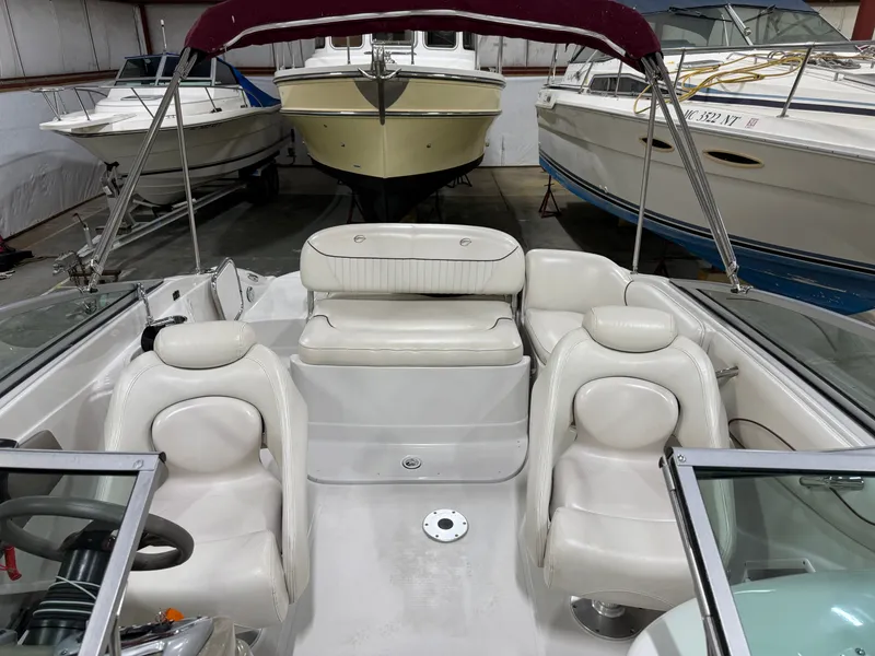 Slide: The Image of The image shows the cockpit of a 2006 Crownline 220 EX boat with white leather seats. - 12