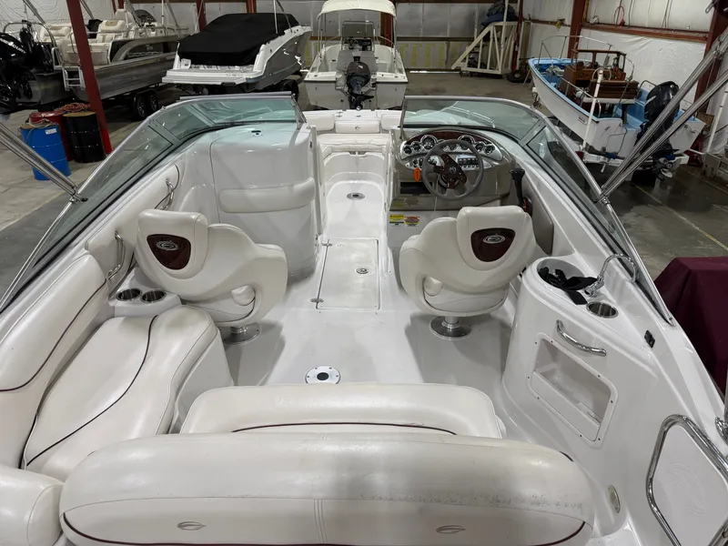Slide: The Image of Interior view of a 2006 Crownline 220 EX boat with white seating and a helm console. - 6