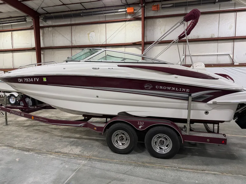 Slide: The Image of A 2006 Crownline 220 EX boat on a trailer inside a warehouse. - 1