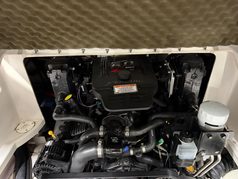 Slide: The Image of The engine compartment of a 2006 Crownline 220 EX shows a Mercury engine with hoses and wires. - 18