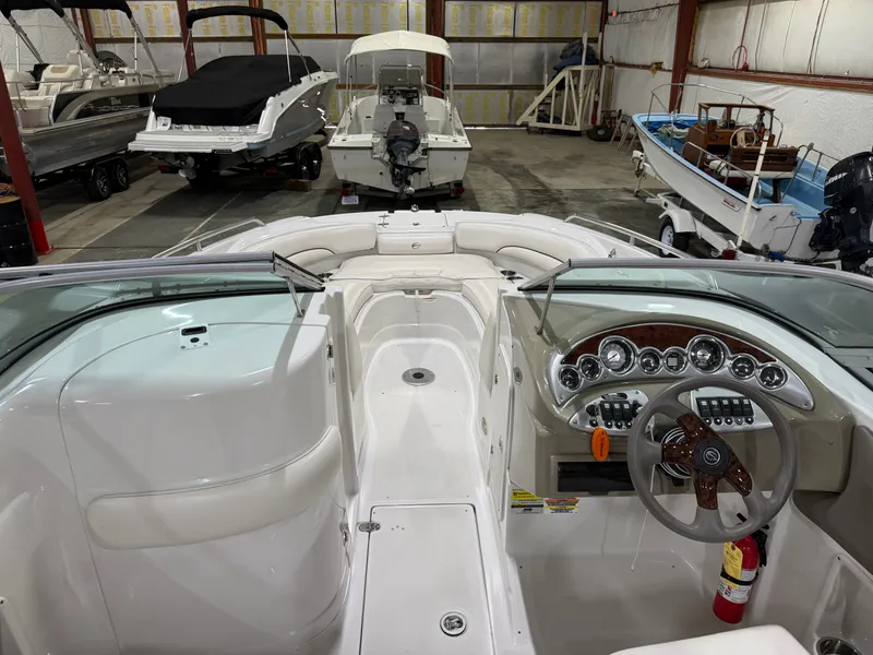 Slide: The Image of The image shows the cockpit of a 2006 Crownline 220 EX boat in a storage facility. - 7