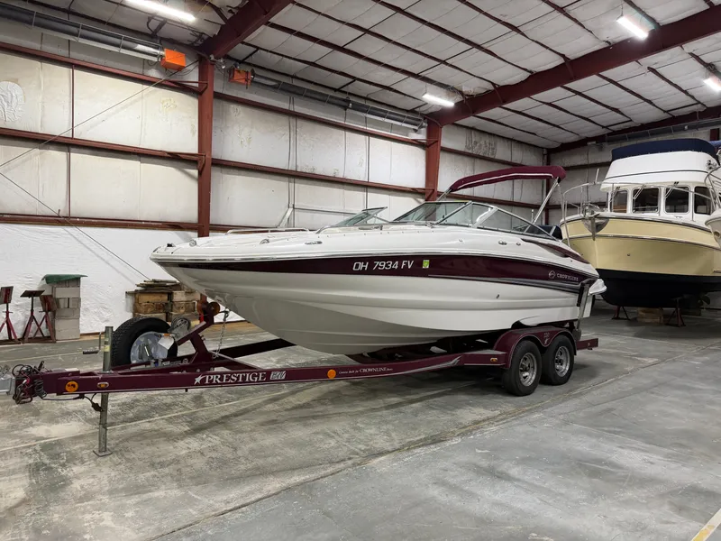 The Image of A 2006 Crownline 220 EX boat on a trailer inside a warehouse. - 0