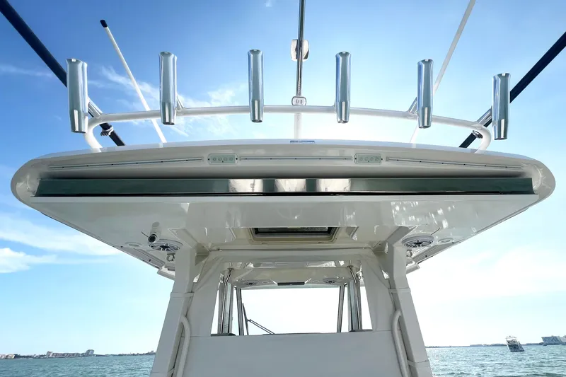 Slide: The Image of 2023 Pursuit S 378 Sport boat, showcasing sleek design and rod holders against a clear sky. - 39