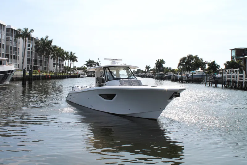 Slide: The Image of 2023 Pursuit S 378 Sport boat cruising in a sunny waterfront setting. - 2