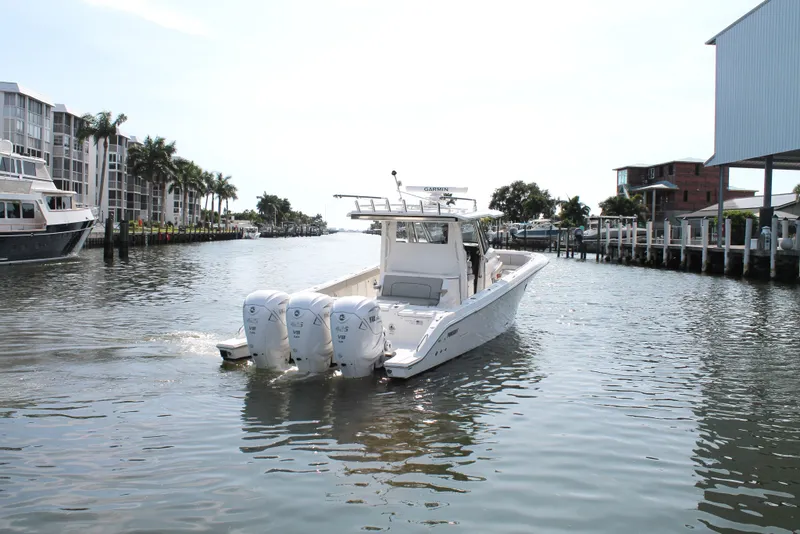 Slide: The Image of 2023 Pursuit S 378 Sport boat cruising in a scenic waterfront area. - 9