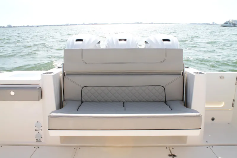 Slide: The Image of 2023 Pursuit S 378 Sport boat with cushioned seating and triple engines on open water. - 20