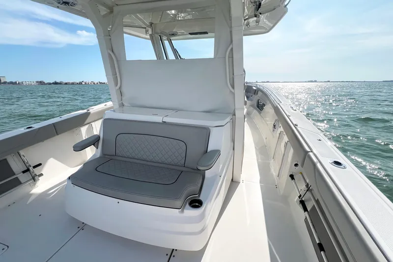 Slide: The Image of 2023 Pursuit S 378 Sport boat interior with cushioned seating, on a sunny day at sea. - 27