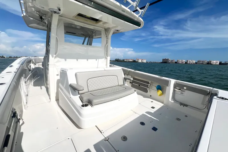 Slide: The Image of 2023 Pursuit S 378 Sport boat interior with seating, on a sunny day by the water. - 25