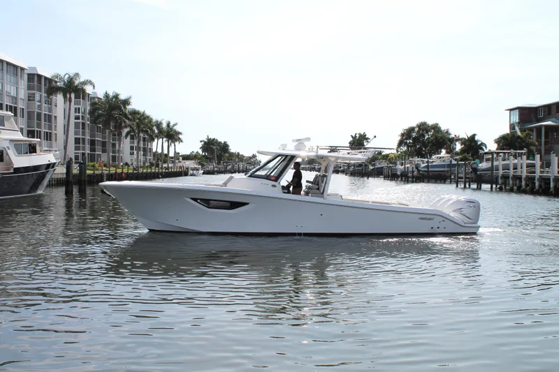 Slide: The Image of 2023 Pursuit S 378 Sport boat cruising in a scenic waterfront area. - 5