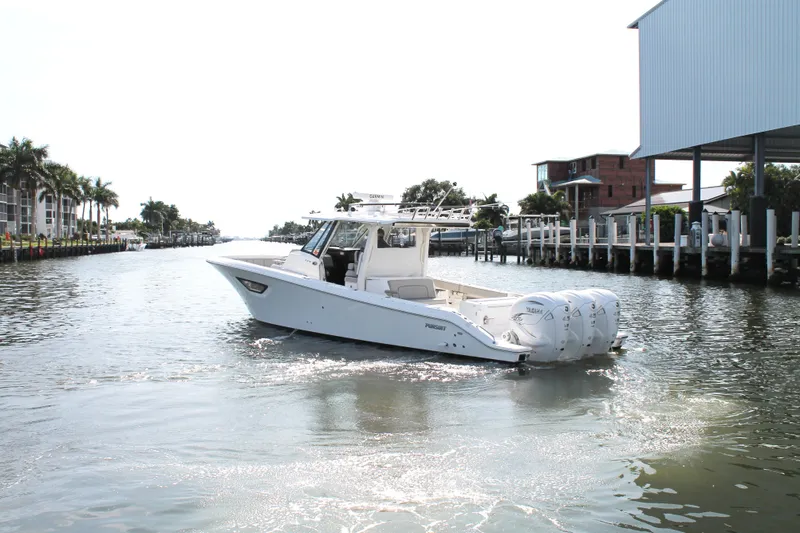 Slide: The Image of 2023 Pursuit S 378 Sport boat cruising in a scenic waterfront setting. - 6