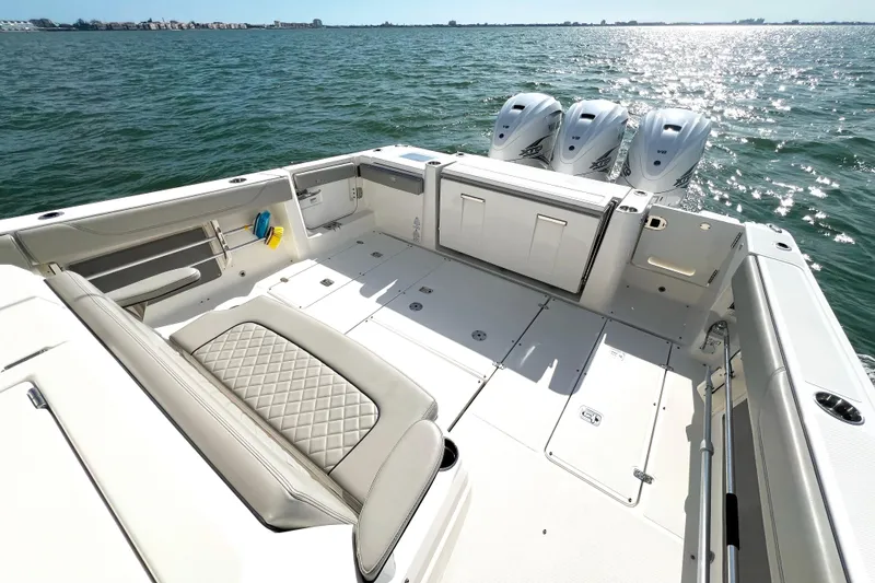 Slide: The Image of 2023 Pursuit S 378 Sport boat deck with triple V8 engines on open water. - 15