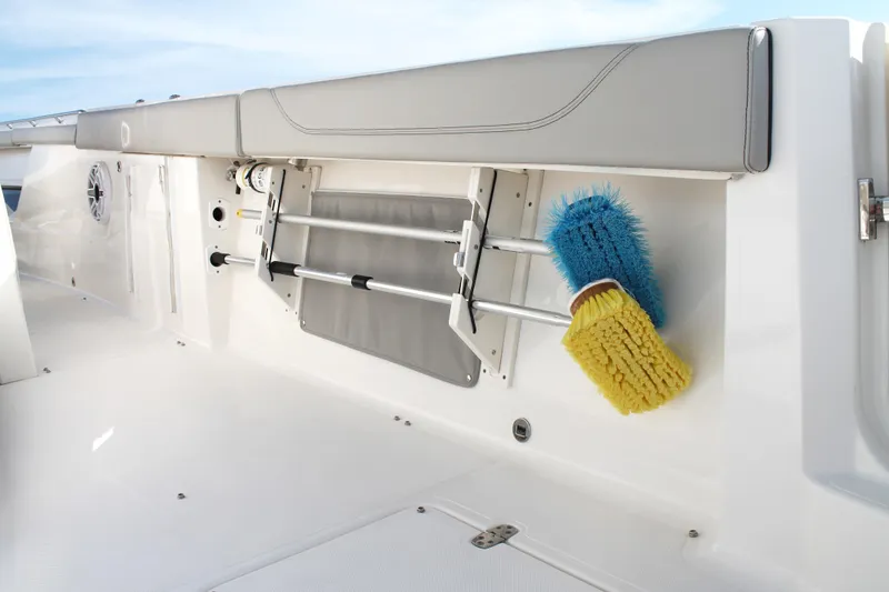 Slide: The Image of 2023 Pursuit S 378 Sport boat interior with cleaning brushes and storage compartment. - 24