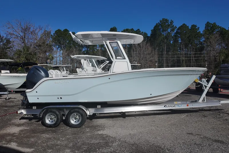 Slide: The Image of 2026 Sea Fox 228 Commander boat on trailer, parked outdoors under clear blue sky. - 1