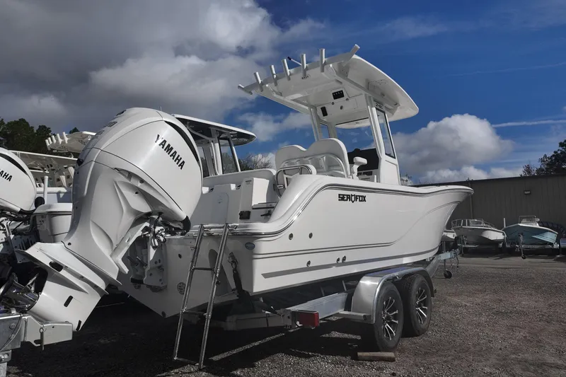 Slide: The Image of 2026 Sea Fox 248 Commander boat with Yamaha engine on trailer under cloudy sky. - 2