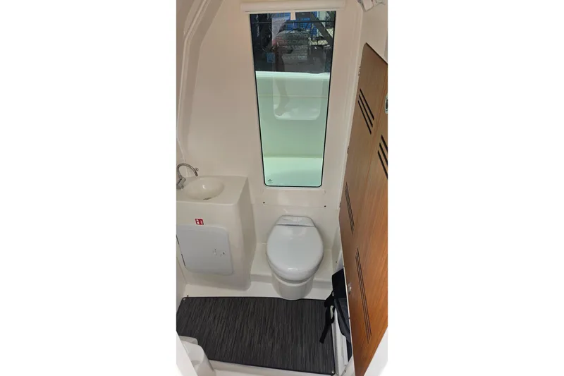 Slide: The Image of Compact bathroom in 2027 Solace 28HCS boat with toilet, sink, and window. - 23