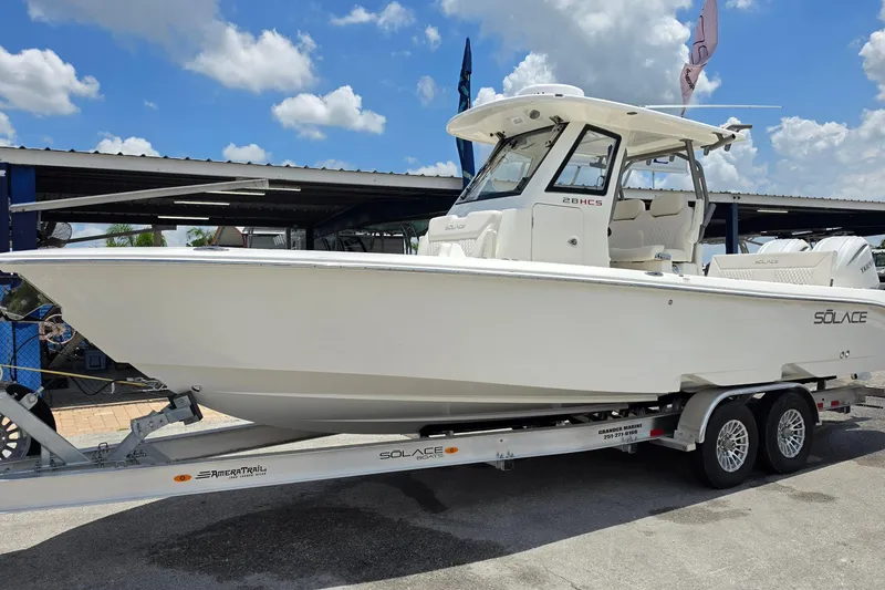 The Image of 2027 Solace 28HCS boat on trailer under blue sky with clouds. - 1
