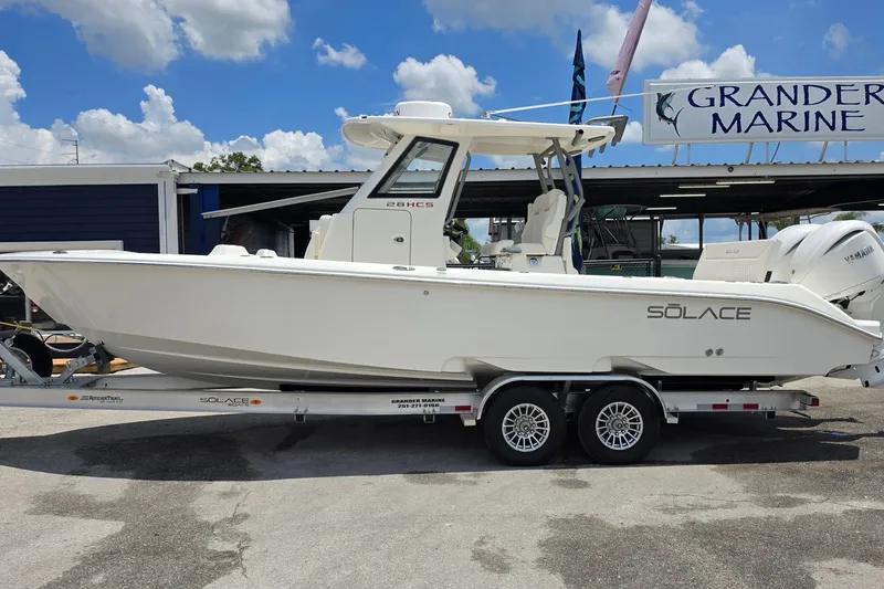 Slide: The Image of 2027 Solace 28HCS boat on trailer at Grander Marine dealership. - 2