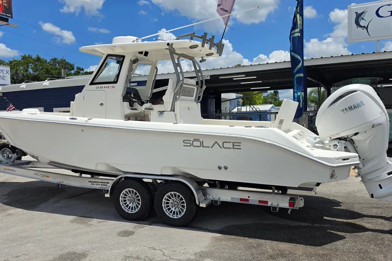 Slide: The Image of 2027 Solace 28HCS boat on trailer, featuring Yamaha outboard motor, displayed outdoors. - 3
