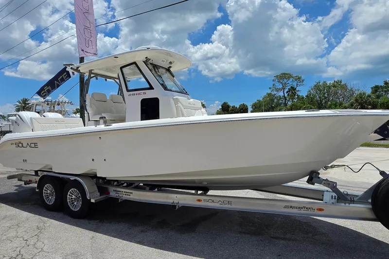 Slide: The Image of 2027 Solace 28HCS boat on trailer under blue sky with clouds. - 7